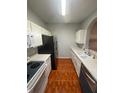 Kitchen with white cabinets, appliances, tile flooring, and bright lighting at 13560 Turtle Marsh Loop # 319, Orlando, FL 32837