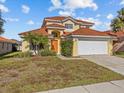 Two-story house with a tan exterior, tile roof, and a two-car garage at 204 Paloma Dr, Davenport, FL 33837