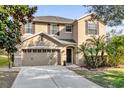 Two-story house with tan siding, brown accents, and a two-car garage at 20811 Sullivan Ranch Blvd, Mount Dora, FL 32757