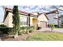 Landscaped yard with a one-story house and brown garage door at 273 Ancona Ave, Debary, FL 32713