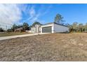 White house with a gray garage door and grassy yard at 2831 Sw 166Th Ln, Ocala, FL 34473