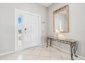 Bright entryway with a white door, a console table, and a large mirror at 305 Therese St, Davenport, FL 33897