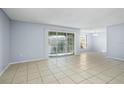Living room with tile floors and sliding glass doors leading to a balcony at 4172 Versailles Dr # 4172D, Orlando, FL 32808