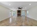 Cozy living room boasting a stone fireplace, ceiling fan, and french doors for natural light and access at 2961 Cedar Glen Pl, Oviedo, FL 32765