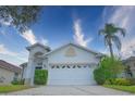 White house with a two-car garage, landscaping, and palm trees at 4911 Santa Clara Dr, Orlando, FL 32837