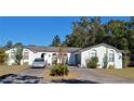 White single story home with a circular driveway and cacti at 547 Queens Mirror Cir, Casselberry, FL 32707