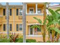 Close-up of two-story townhome entrance, featuring yellow painted walls and lush landscaping at 8451 Leatherleaf Ln, Orlando, FL 32827