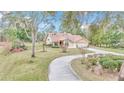 Inviting home with a circular drive, lush landscaping, and mature trees in a serene setting at 8520 Sw 209Th Ct, Dunnellon, FL 34431