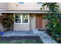 Front entrance of a tan house with a brown door and landscaping at 1009 Grove St # 90, Maitland, FL 32751