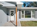 Inviting front entrance with white door, wreath, and stone walkway at 30722 Cove Rd, Tavares, FL 32778