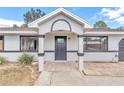 Modern front entrance with gray door, white columns, and stone flooring at 37 Hickory Track Way, Ocala, FL 34472