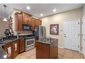 Kitchen with island, stainless steel appliances, and wood cabinets at 8426 Chamberlain Pl, Oviedo, FL 32765