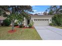 House exterior featuring a two-car garage and manicured lawn at 10952 Arbor View Blvd, Orlando, FL 32825