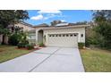 House exterior featuring a two-car garage and manicured lawn at 10952 Arbor View Blvd, Orlando, FL 32825