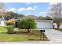 Single-story house with a two-car garage and well-maintained lawn at 142 Santana Pl, Davenport, FL 33897