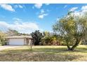 Landscaped yard and stone house exterior with attached garage at 1429 Royal Palm Dr, Edgewater, FL 32132