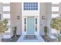 Charming teal front door with sidelights and a welcome mat at 2718 Se 45Th Ave, Ocala, FL 34480