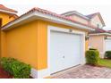 Attached garage with white door and brick pavers at 308 Robin Rd, Davenport, FL 33896