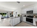 Open kitchen with island, stainless steel appliances, and granite countertops at 3326 Private Oak Dr, Apopka, FL 32703