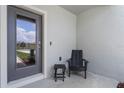 Small front porch with gray door and black chair at 3332 Private Oak Dr, Apopka, FL 32703