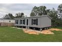 Gray manufactured home with black shutters and a spacious yard at 3548 Valley Trl, Lakeland, FL 33810