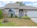 Gray siding, arched window, and gray door. Landscaped front yard at 430 Magpie Ct, Kissimmee, FL 34759