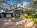 House exterior featuring brick driveway, stone accents, and lush landscaping at 4390 Saxon Dr, New Smyrna Beach, FL 32169