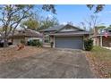 House exterior showcasing a gray garage door and landscaped yard at 440 Macgregor Rd, Winter Springs, FL 32708
