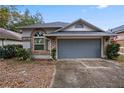 One-story house with gray garage door and brick accents at 440 Macgregor Rd, Winter Springs, FL 32708