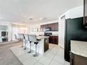 Modern kitchen with dark wood cabinets, granite countertops, and an island at 6163 Forest Ridge Way, Winter Haven, FL 33881