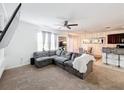 Open-concept living room with cozy gray sectional, large TV, and neutral tones at 6163 Forest Ridge Way, Winter Haven, FL 33881