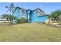 Front view of two-story light blue house with landscaping at 1001 Dampierre Ct, Kissimmee, FL 34759