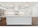 Modern kitchen with white cabinetry, stainless steel appliances, pendant lighting, and a large island at 13200 Faro Ct # 44, Winter Garden, FL 34787