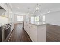 Stylish kitchen with stainless steel appliances, white cabinets, an island, and dark hardwood floors at 13200 Faro Ct # 44, Winter Garden, FL 34787