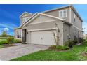 Two-story house with gray siding, a two-car garage, and well-maintained landscaping at 13615 Ritta Island Dr, Orlando, FL 32827