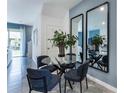 Modern dining area with glass table, four blue chairs, and mirrors at 1519 Isleta Loop, Kissimmee, FL 34741