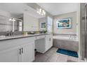 Modern bathroom with double vanity, soaking tub, and walk-in shower at 1564 Flange Dr, Davenport, FL 33896