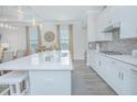 Open kitchen with white island, quartz countertops, and stainless steel appliances at 1987 Key Bay Trl, Kissimmee, FL 34747