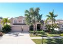 Two-story house with three-car garage, landscaping, and palm trees at 437 Prestwick Dr, Davenport, FL 33897