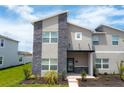 Modern two-story home with gray exterior and stone accents at 1176 Challenge Dr, Davenport, FL 33896