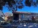 Front view of a tan house with a brown roof, fenced yard, and solar panels at 1332 Azalea Way, Winter Garden, FL 34787