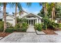 White house exterior with lush landscaping and a stone pathway at 1611 Walnut Ave, Winter Park, FL 32789