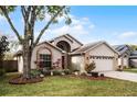 Tan house with mature trees and well-manicured lawn at 1621 Riveredge Rd, Oviedo, FL 32766