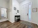 Bright foyer with wood floors, white walls, and a decorative front door with sidelight at 190 Crepe Myrtle Dr, Groveland, FL 34736