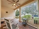 Inviting front porch with a ceiling fan, brick floor, and view of the landscaped yard at 190 Crepe Myrtle Dr, Groveland, FL 34736