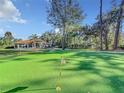 Expansive putting green surrounded by lush landscaping and large trees at 3415 S Mellonville Ave, Sanford, FL 32773