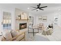 Bright living room featuring a brick fireplace, modern fan, neutral decor, and access to outdoor spaces at 417 Main Trl, Ormond Beach, FL 32174