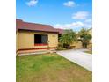 Front view of a yellow house with red tile roof, palm trees, and a landscaped yard at 743 Golden Sunshine Cir, Orlando, FL 32807