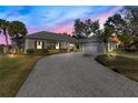 Elegant home exterior featuring a gray brick driveway, manicured landscaping, and tasteful architectural design elements at 8513 Bay Hill Blvd, Orlando, FL 32819