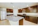 Kitchen featuring granite countertops, stainless steel appliances, and dark brown cabinets at 1147 Moyle Way, Mascotte, FL 34753